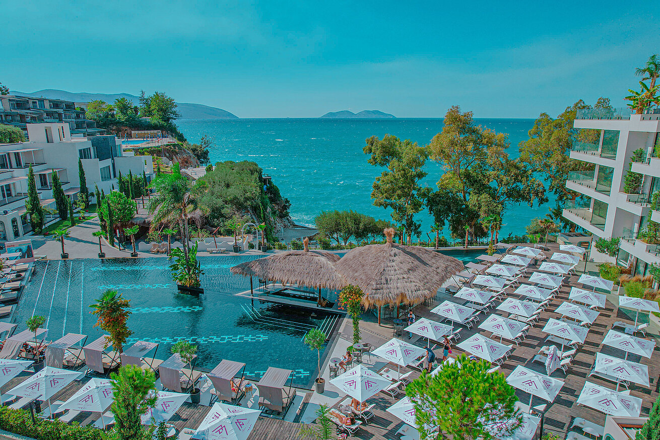 Poollandschaft mit Sonnenschirmen und Meerblick im Maritim Resort Marina Bay