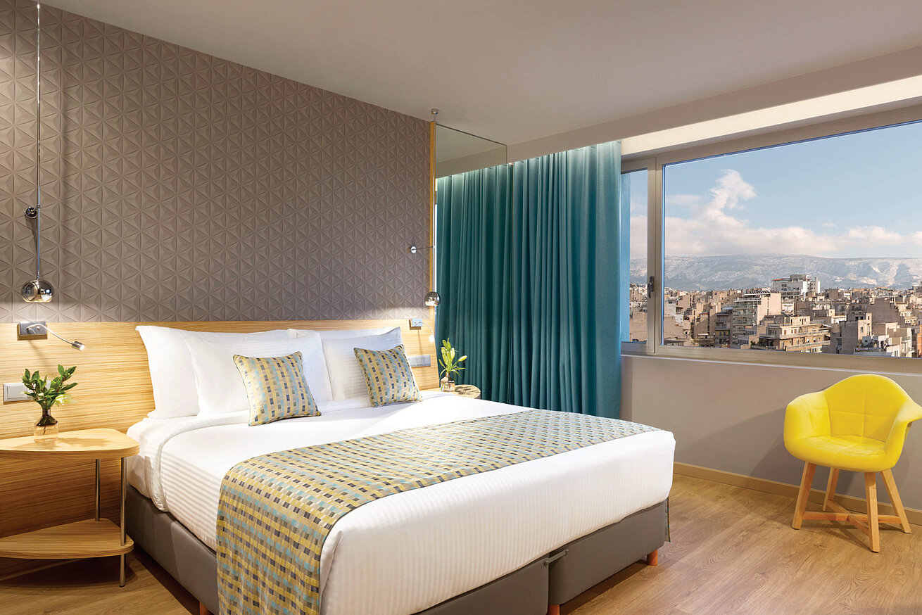 Helles Executive Zimmer im Wyndham Grand Athen mit Blick über die Stadt und Berge