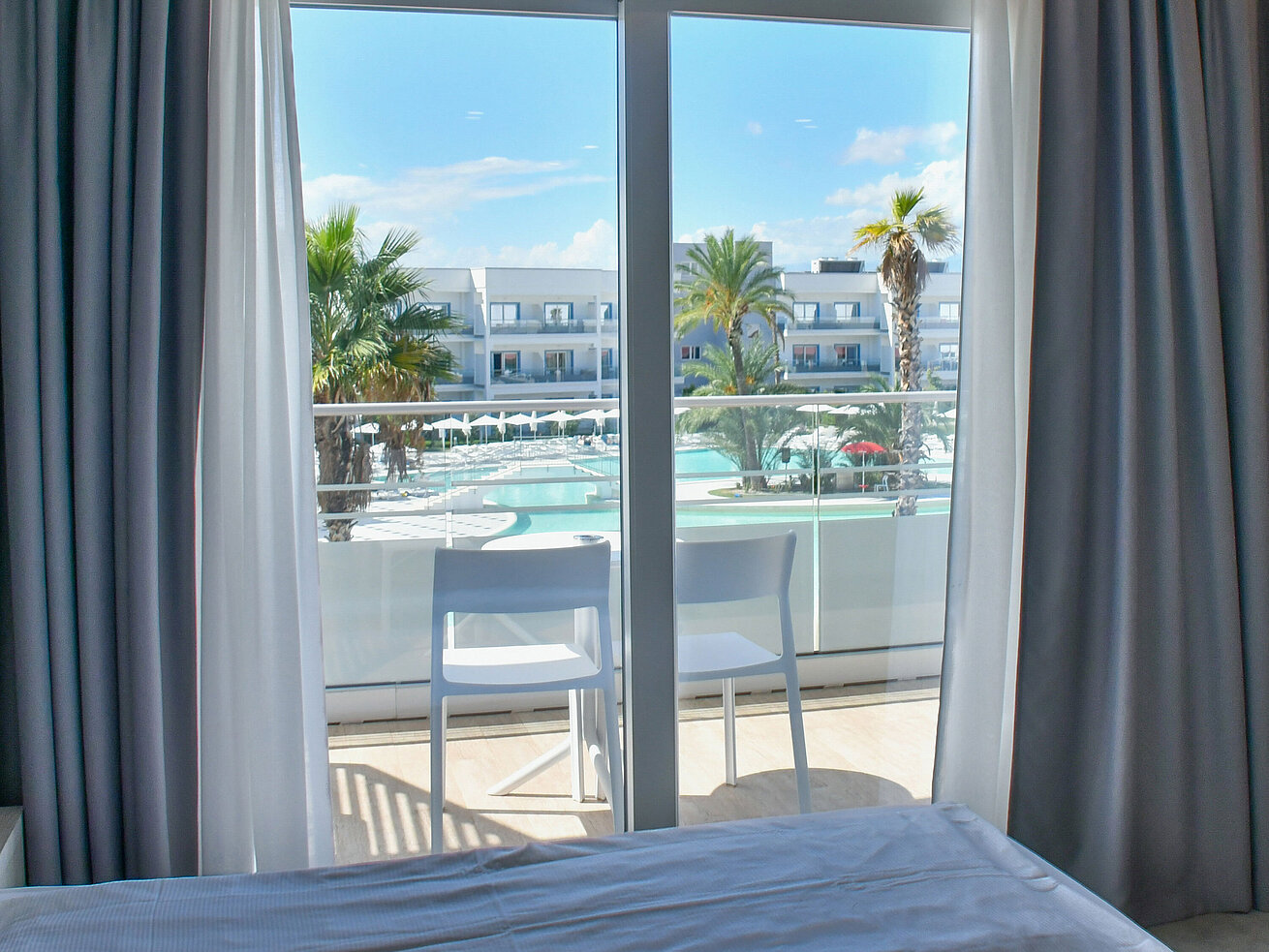 Blick vom Hotelzimmerbalkon im Maritim Resort Calabria auf Pool, Palmen und Hotelanlage