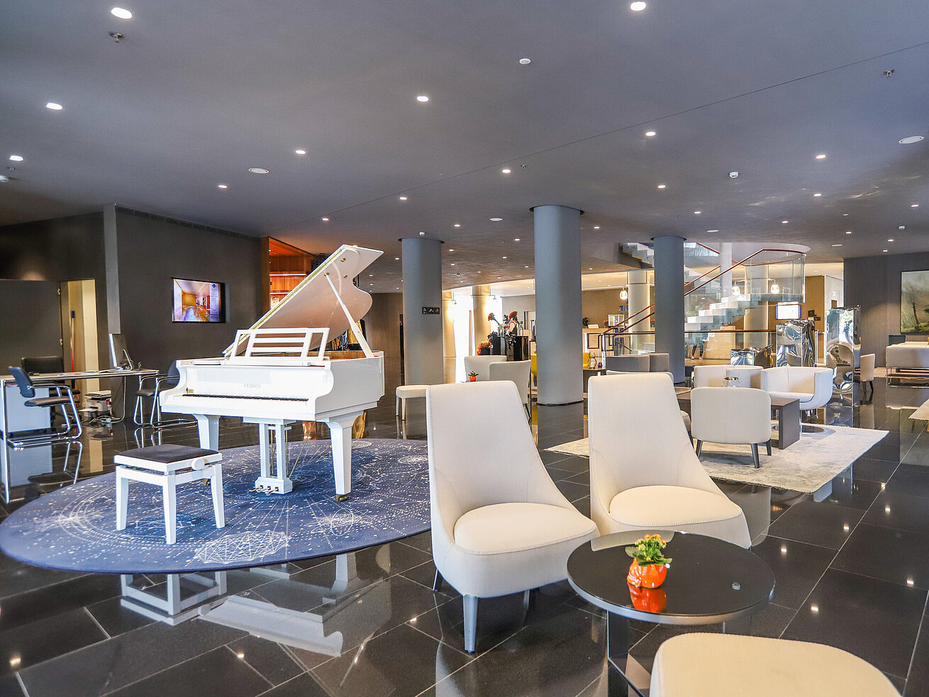 Elegante Hotellobby mit weißem Flügel und stilvollen Sitzgruppen im Maritim Hotel Plaza Tirana